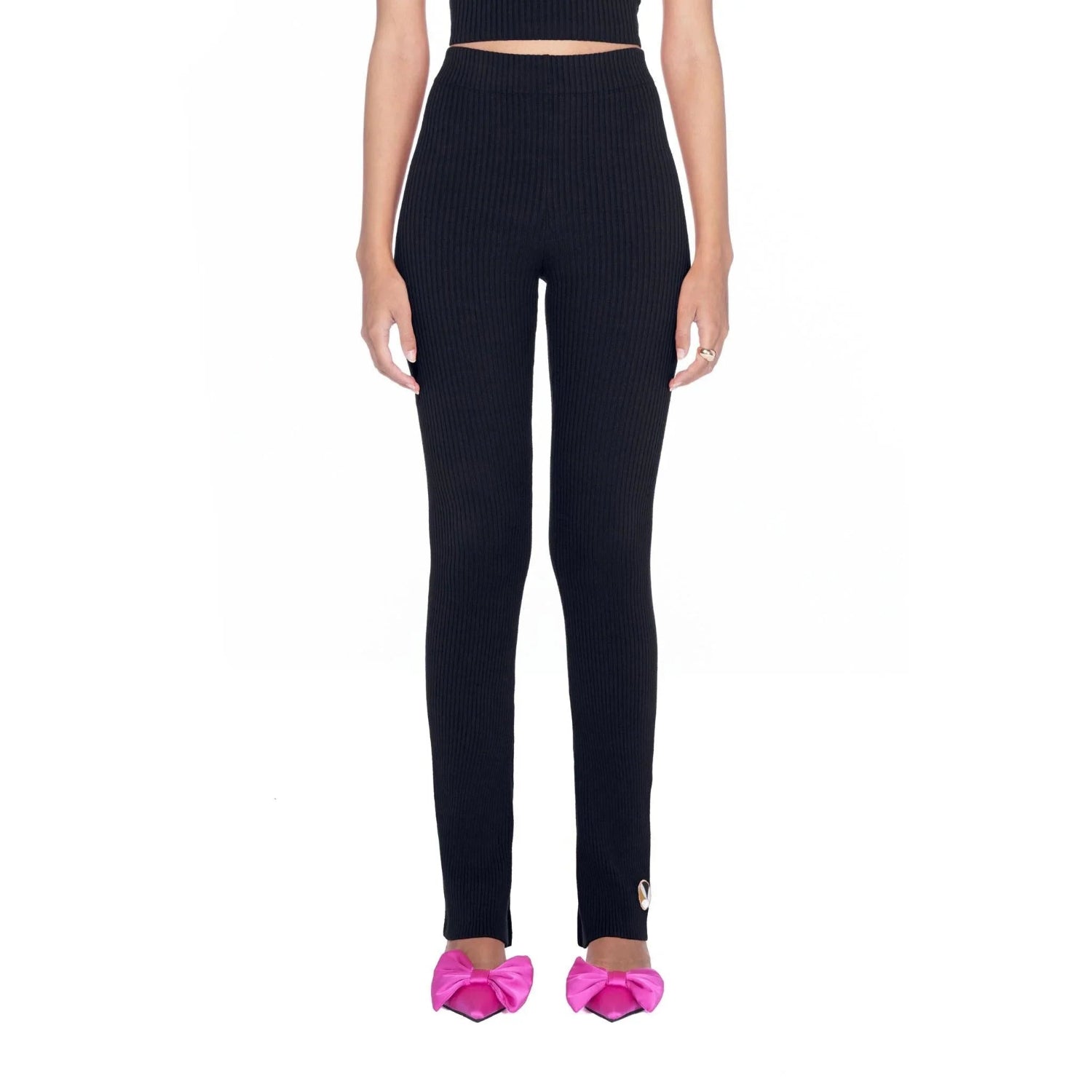 Woman wearing black flared ribbed leggings with high waist, paired with pink bow heels