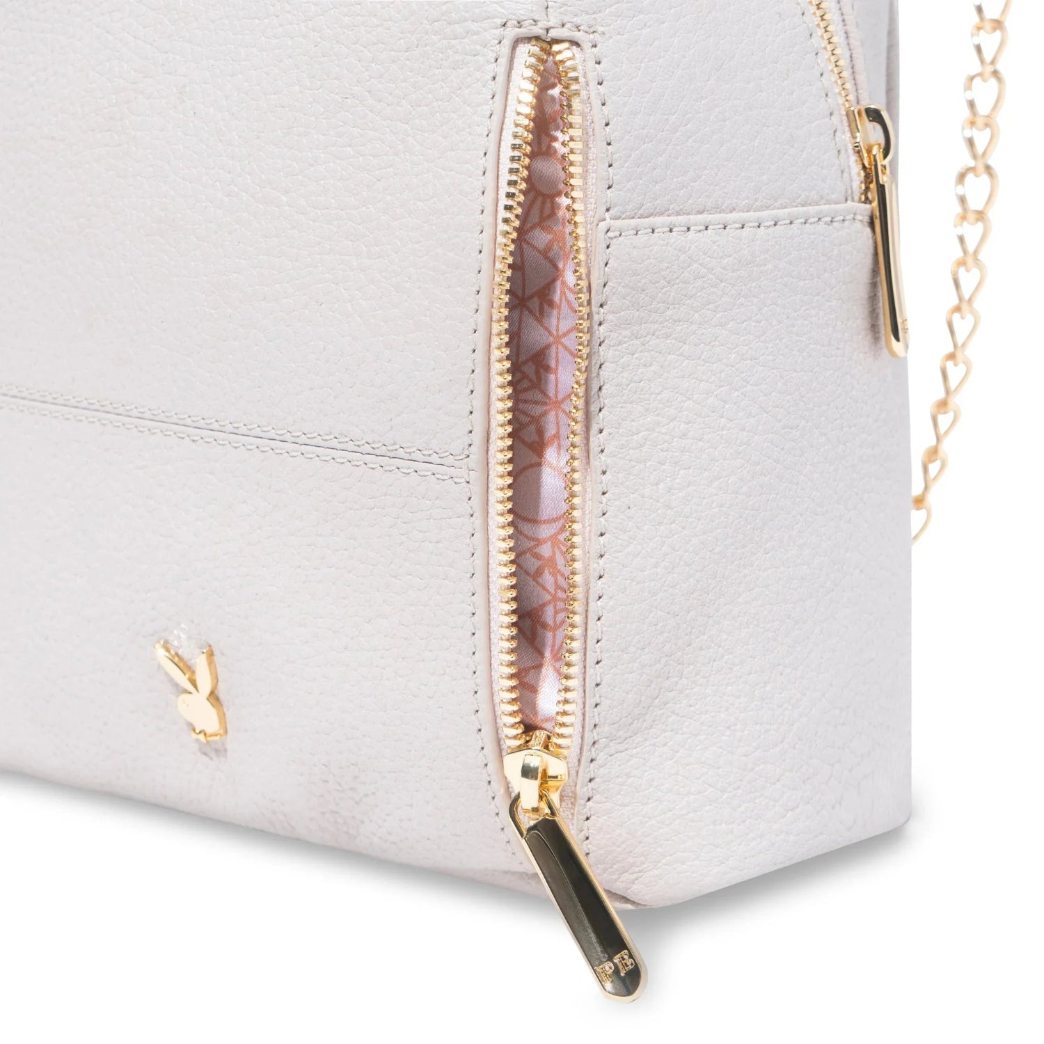 Close-up of a white leather mini backpack with gold zippers, chain strap, and side pocket.