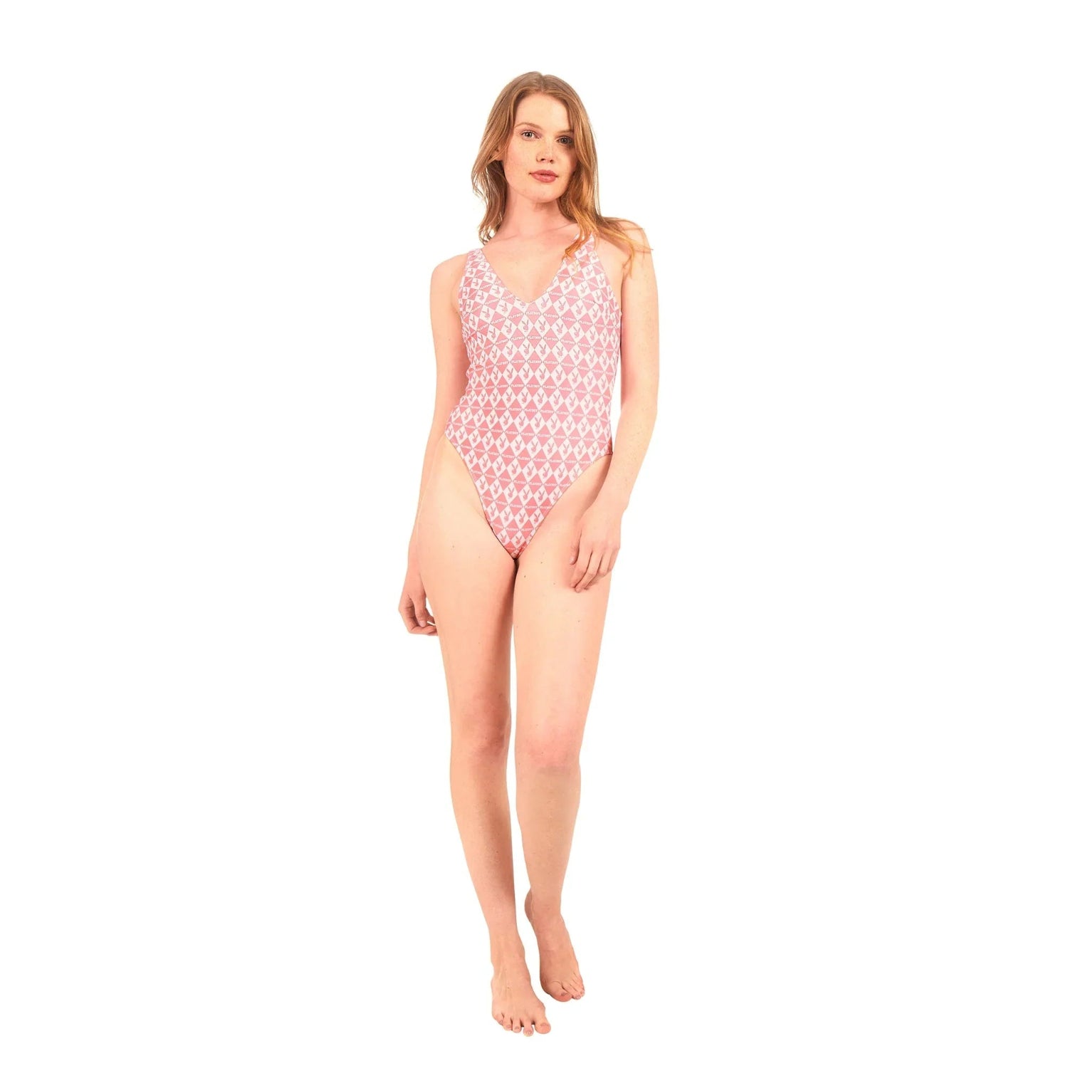 Woman wearing pink one-piece monogram swimsuit with V-neck, standing against white background