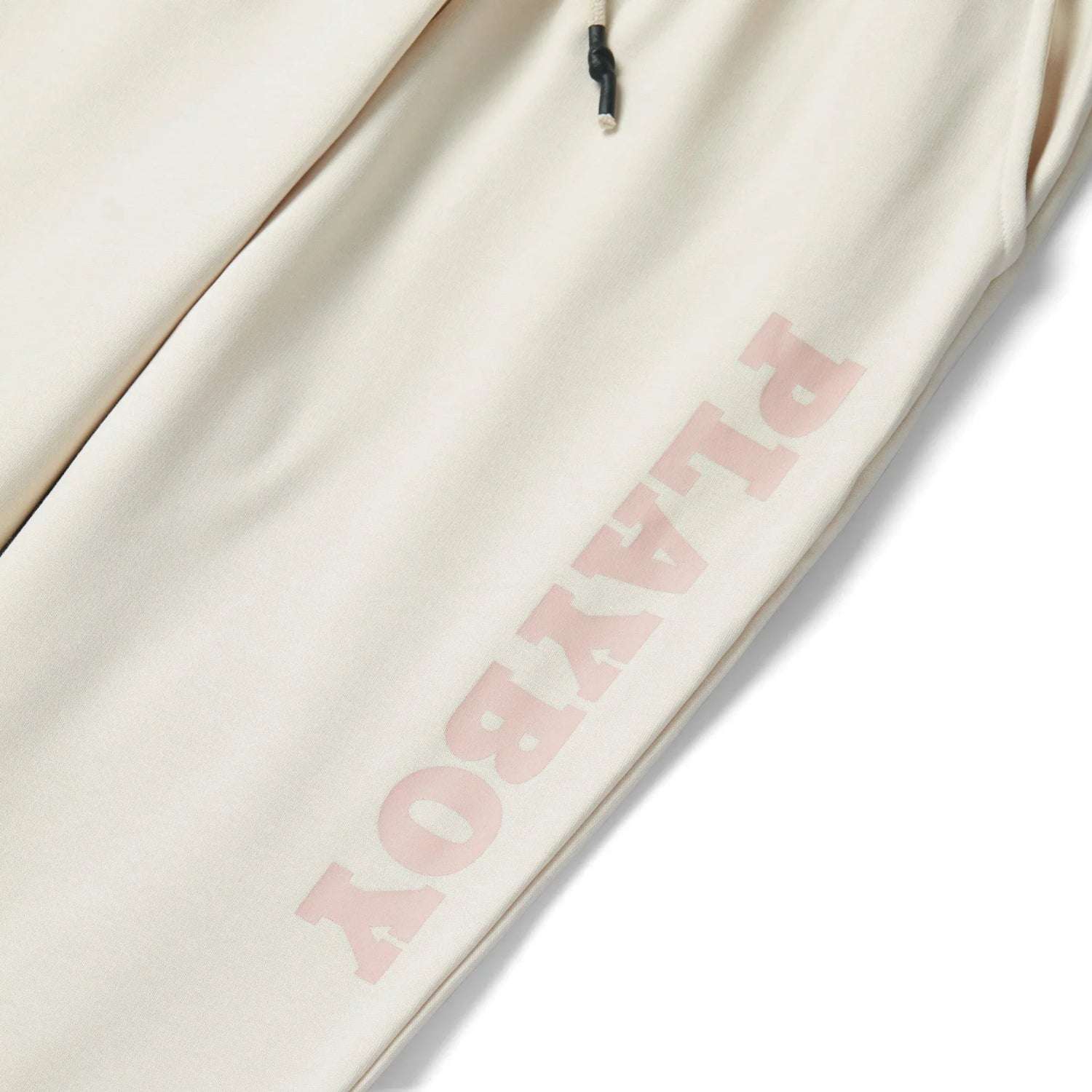 Beige women's oversized joggers with pink lettering on leg and drawstring waist detail