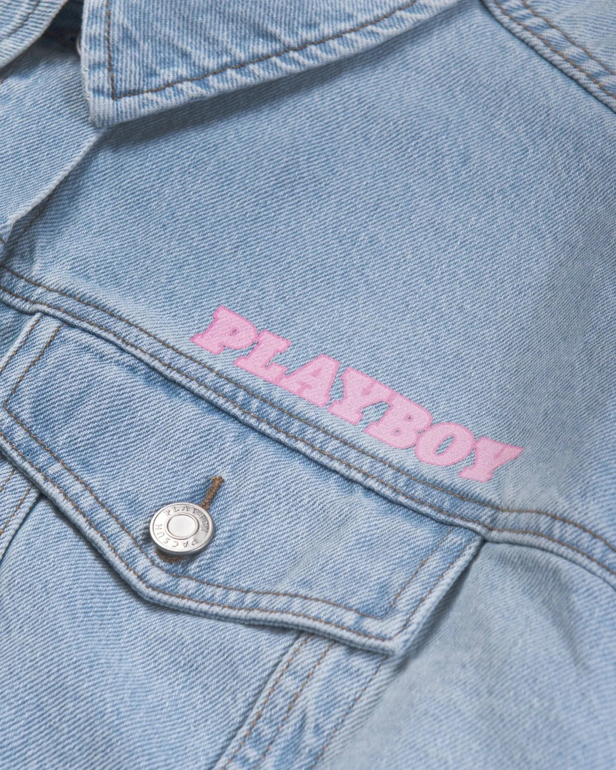 Light blue denim jacket with pink embroidered PLAYBOY text above front pocket