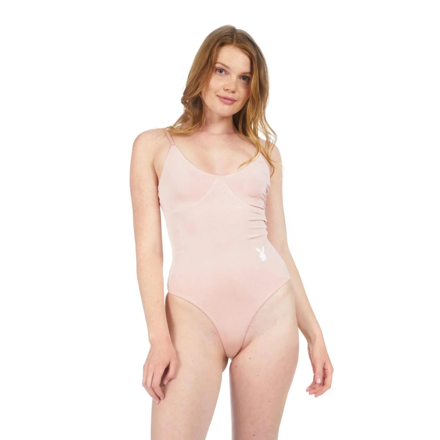 Woman wearing a light pink bodysuit with thin straps and bunny logo, studio background