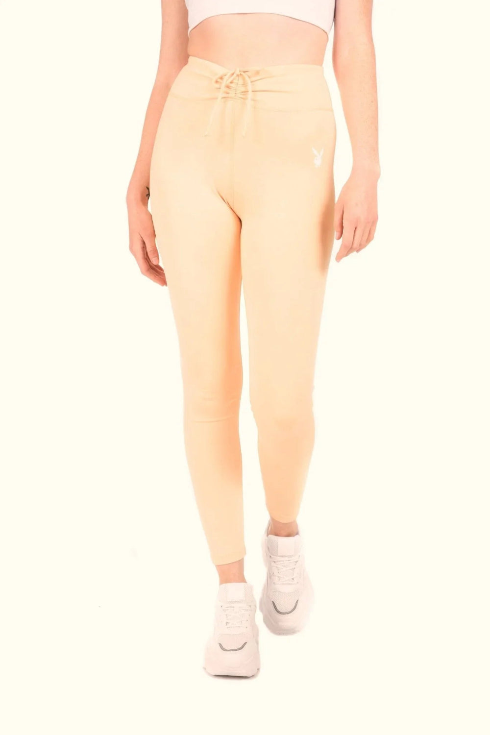 Women’s peach high-waisted ruched leggings with drawstring waistband and white logo