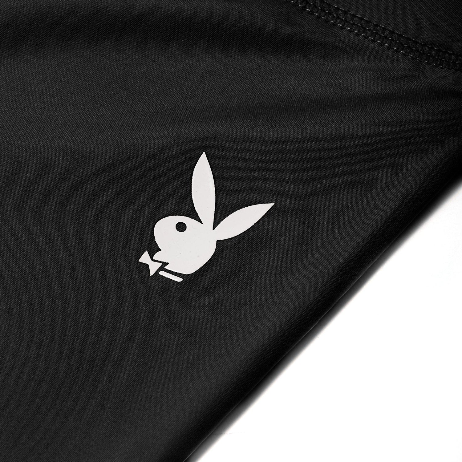 Close-up of black active leggings with white bunny logo and visible stitching detail