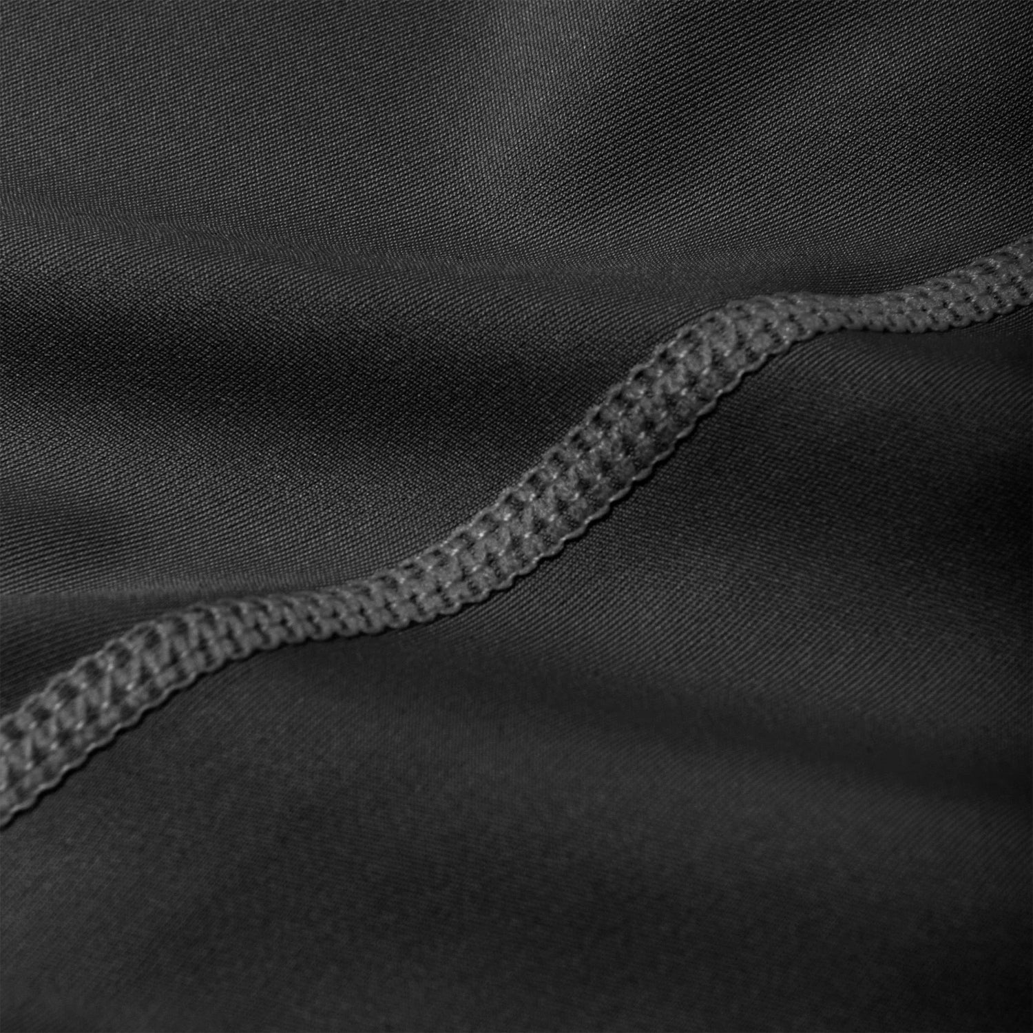 Close-up of black active leggings fabric with visible ruched waistband stitching