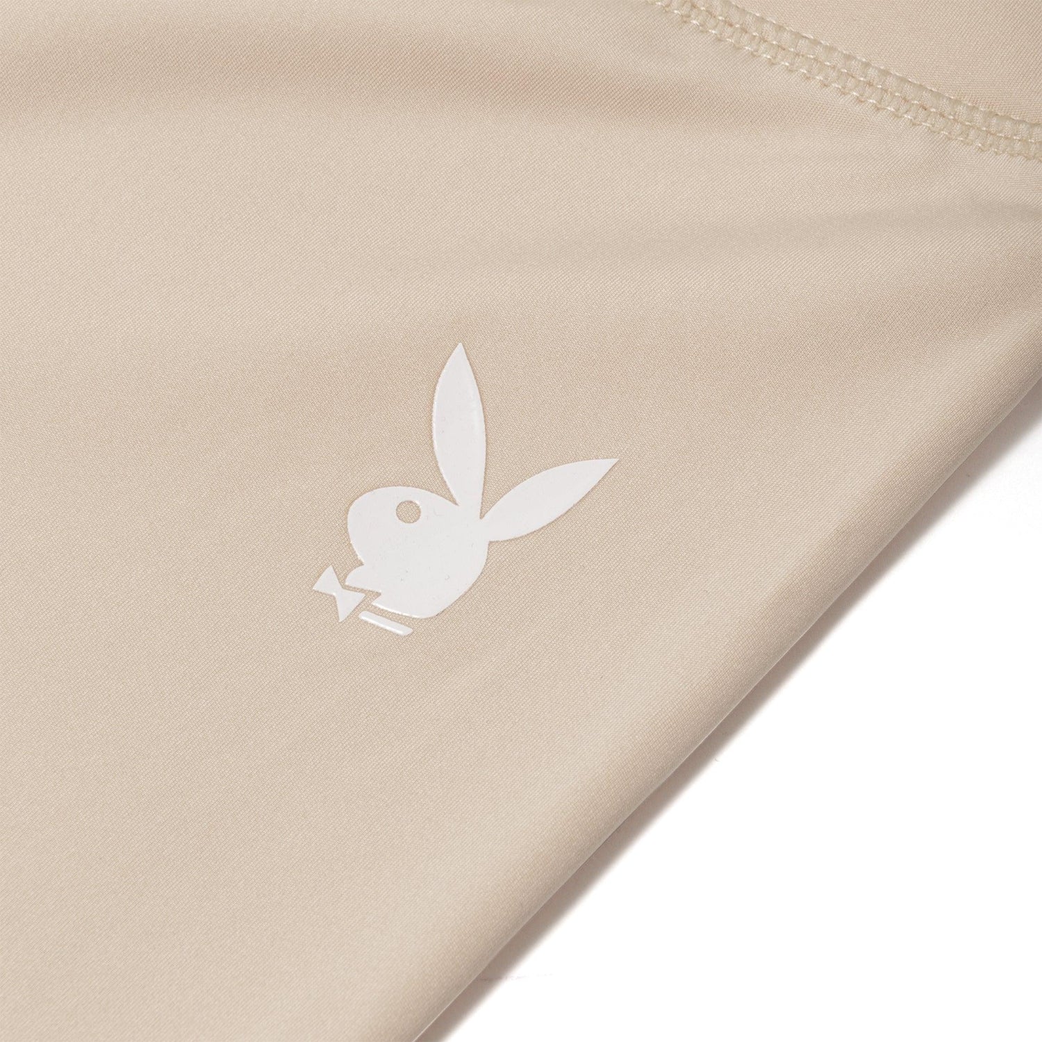 Beige women's leggings with white bunny logo graphic and visible stitching detail